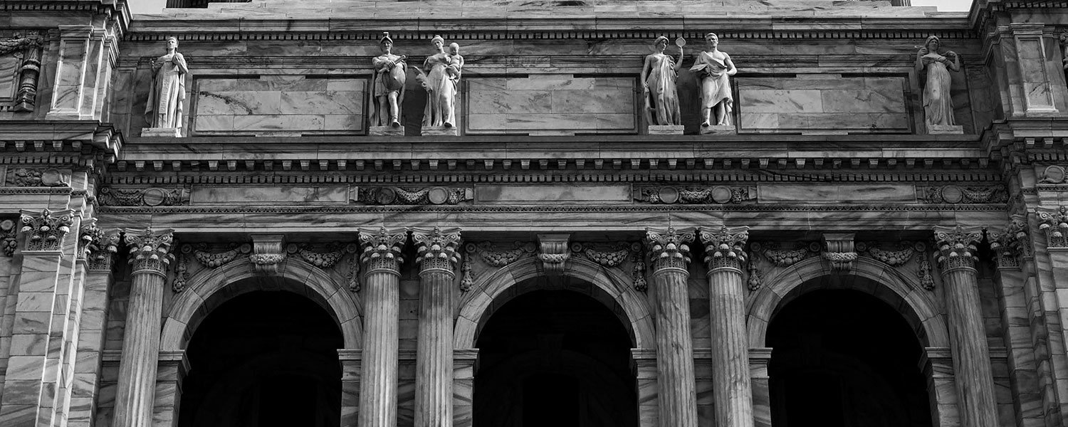 ornate exterior of building with statues and pillars